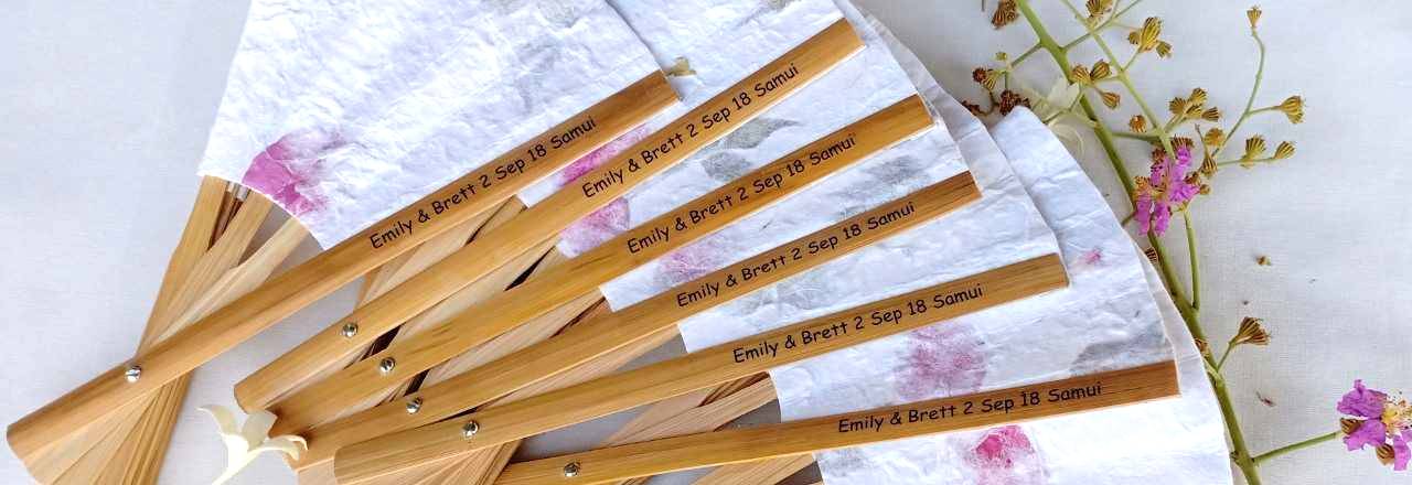 Clear sticker with names & date on the handle of a bamboo wedding fan