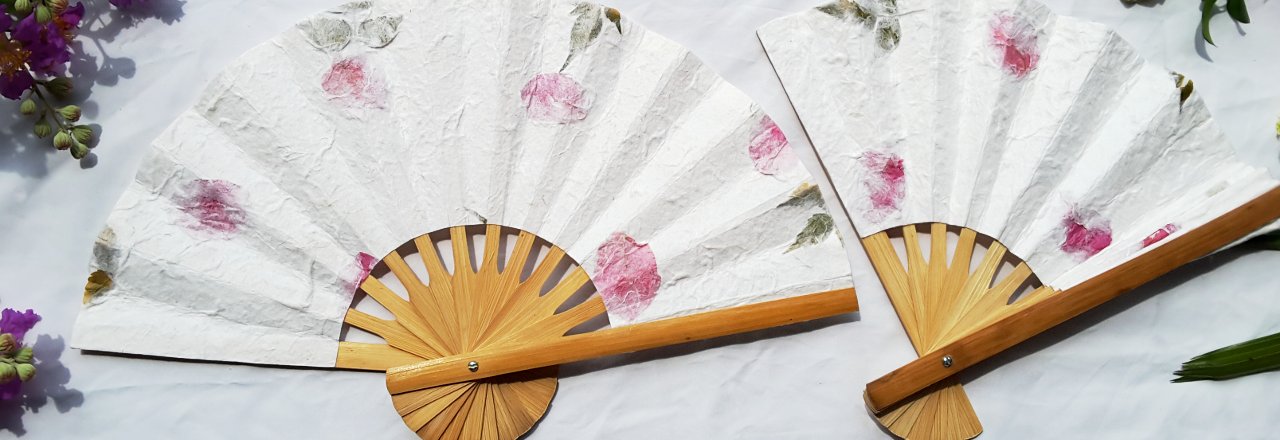 Two pressed flowers wedding fans on a table